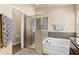 Bathroom features a glass enclosed shower, soaking tub, tile surround and neutral walls at 1426 Main St, Valrico, FL 33594