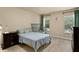 Bedroom with laminate floors, crib, windows with blinds, and a wood dresser on display at 1426 Main St, Valrico, FL 33594