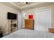 Neutral bedroom features a ceiling fan, closet, wood dresser, flat screen television, and shelving at 1426 Main St, Valrico, FL 33594