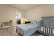Bedroom with wood floors, crib, and natural light. Includes a small desk, chair and dresser at 1426 Main St, Valrico, FL 33594