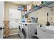Bright laundry room with modern washer, dryer, shelving and utility sink at 1426 Main St, Valrico, FL 33594