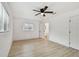 Bedroom with fan, light floors, two windows, and bathroom visible through door at 1621 S Keene Rd, Clearwater, FL 33756