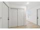 Bright hallway with white walls, light wood flooring, and a double door closet for ample storage at 1621 S Keene Rd, Clearwater, FL 33756