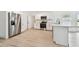 Bright kitchen with white cabinets, a stainless steel refrigerator, a modern microwave, and a breakfast bar at 1621 S Keene Rd, Clearwater, FL 33756