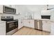 Modern kitchen featuring stainless steel appliances, white cabinets, quartz countertops, and an open layout at 1621 S Keene Rd, Clearwater, FL 33756