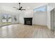 Bright living room featuring a fireplace, ceiling fan, tall ceilings, and light wood flooring at 1621 S Keene Rd, Clearwater, FL 33756