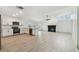 Bright, open-concept living area with modern light wood floors, a black fireplace, and a ceiling fan at 1621 S Keene Rd, Clearwater, FL 33756