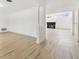 Open-concept living area featuring light wood flooring, white walls, and a modern fireplace at 1621 S Keene Rd, Clearwater, FL 33756