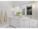 Bright bathroom featuring a double vanity with marble countertop, gold hardware, and a large mirror at 216 N Hesperides St, Tampa, FL 33609
