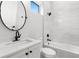 Modern bathroom featuring a tiled shower, oval mirror, and vanity sink at 216 N Hesperides St, Tampa, FL 33609