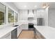 Modern kitchen featuring stainless steel appliances, white cabinets, and plenty of counter space at 216 N Hesperides St, Tampa, FL 33609