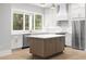 Bright kitchen with stainless steel appliances, white cabinetry, and a center island at 216 N Hesperides St, Tampa, FL 33609