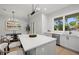 Bright kitchen with island, stainless steel dishwasher, quartz countertops, and large windows at 216 N Hesperides St, Tampa, FL 33609