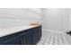 A laundry room with navy cabinets, gold hardware, and gray and white patterned tile at 216 N Hesperides St, Tampa, FL 33609