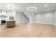 Open concept living space with wood-look tile floors, modern lighting, and kitchen at 216 N Hesperides St, Tampa, FL 33609