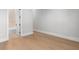 An empty bedroom with hardwood floors, neutral colored walls, a white door and trim at 222 N Hesperides St, Tampa, FL 33609