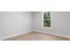 An empty bedroom with hardwood floors, neutral colored walls and a window with natural light at 222 N Hesperides St, Tampa, FL 33609