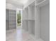 Walk-in closet featuring white shelving, white flooring, and natural light at 222 N Hesperides St, Tampa, FL 33609