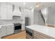 Contemporary kitchen design with stainless steel appliances, white cabinets, an island, and an open staircase at 222 N Hesperides St, Tampa, FL 33609