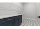 Laundry room featuring navy blue cabinets, modern tile floors, and white walls at 222 N Hesperides St, Tampa, FL 33609