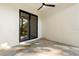 Neutral tiled patio features a ceiling fan and large black-framed sliding glass doors overlooking the yard at 222 N Hesperides St, Tampa, FL 33609