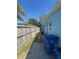 Fenced backyard featuring a blue exterior wall, concrete walkway, and a blue trash receptacle, offering privacy and functionality at 2344 Tahitian Dr, Holiday, FL 34691