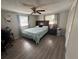 Bedroom with wood-look floors, ceiling fan, and natural light from the windows at 2344 Tahitian Dr, Holiday, FL 34691