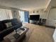 Comfortable living room featuring black leather sofas, a large screen TV and bright blue door at 2344 Tahitian Dr, Holiday, FL 34691