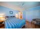 Bright bedroom with light blue walls, hardwood floors, queen-sized bed, and white closet doors at 2720 Lancaster Dr, Sun City Center, FL 33573