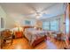Comfortable bedroom with hardwood floors, ceiling fan, side tables, and a well-lit writing desk at 2720 Lancaster Dr, Sun City Center, FL 33573