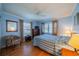Well-lit bedroom featuring hardwood floors, blue walls, with two bright windows and a ceiling fan at 2720 Lancaster Dr, Sun City Center, FL 33573