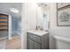 Bright bathroom featuring a gray vanity and an adjacent shelving unit with wicker baskets at 2918 W Ellis Dr, Tampa, FL 33611
