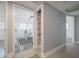 Bright hallway features tile floors, open closet shelving, and leads to a room with plenty of natural light at 2918 W Ellis Dr, Tampa, FL 33611