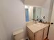 Well-lit bathroom featuring a toilet, sink, vanity, and large mirror at 310 Kensington Lake Cir, Brandon, FL 33511