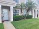 A townhouse with a well-maintained lawn, trimmed shrubs, and two small palm trees at 310 Kensington Lake Cir, Brandon, FL 33511