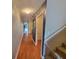 Hallway with hardwood floors leading to other rooms and a staircase with carpeted steps at 310 Kensington Lake Cir, Brandon, FL 33511
