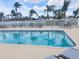 Community pool surrounded by comfortable lounge chairs and palm trees for relaxation at 310 Kensington Lake Cir, Brandon, FL 33511