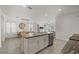 Bright kitchen with island featuring stone countertop, stainless dishwasher, and an open dining area at 31386 Penny Surf Loop, Wesley Chapel, FL 33545