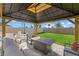 Covered pergola in a backyard featuring outdoor seating and a fire pit for cozy gatherings at 31386 Penny Surf Loop, Wesley Chapel, FL 33545