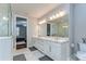 This bright bathroom has marble floors, a double vanity and views into the primary bedroom and glass shower at 3215 W De Leon St # 6, Tampa, FL 33609