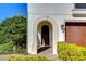 Charming arched doorway with stone trim, a wooden door, and exterior lighting at 3215 W De Leon St # 6, Tampa, FL 33609