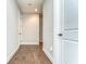 Well-lit hallway with neutral walls, hardwood floors, and white doors at 3215 W De Leon St # 6, Tampa, FL 33609