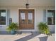Close-up of a charming entrance with double doors, potted plants, and a welcoming ambiance at 3319 Gulf City Rd, Ruskin, FL 33570