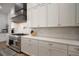 Modern kitchen features gas range, pot filler, modern range hood, and white countertops at 3319 Gulf City Rd, Ruskin, FL 33570