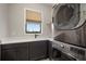 Laundry room features a washer and dryer with a sink with gray cabinets at 3319 Gulf City Rd, Ruskin, FL 33570