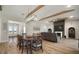 Open living area with hardwood floors, wood beam, modern fireplace, and large windows showing backyard at 3319 Gulf City Rd, Ruskin, FL 33570