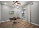 Well-lit office space with wood floors, a desk, a ceiling fan, and a large window with curtains at 3319 Gulf City Rd, Ruskin, FL 33570