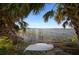 Lake view with boat from under shady palm fronds on a grassy shoreline at 3319 Gulf City Rd, Ruskin, FL 33570