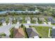 Aerial view of a residential area with a lake and well-maintained houses and green lawns at 34714 Heavenly Ln, Dade City, FL 33525