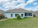 Backyard featuring a lush lawn, mature landscaping, and a covered lanai for outdoor enjoyment at 34714 Heavenly Ln, Dade City, FL 33525
